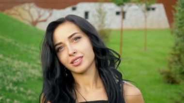 Mutlu gülümseyen esmer yeşil çim üzerinde bir yaz parkında kameradan uzakta çalışır