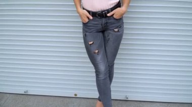 İnce kız gri bir duvara poz