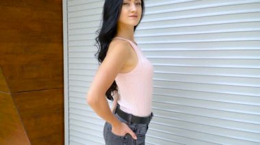 İnce kız gri bir duvara poz