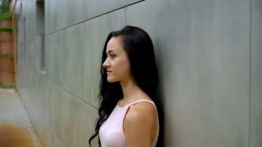 İnce kız gri bir duvara poz