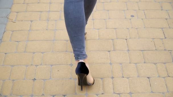 Жінки ноги в туфлях на високих підборах, що ходять по дорозі повільний рух . — стокове відео