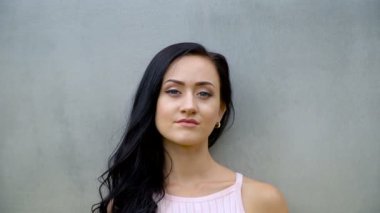 İnce kız gri bir duvara poz