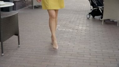 Kamera genç ve çekici bir kızı izliyor. Kadınlar yürür