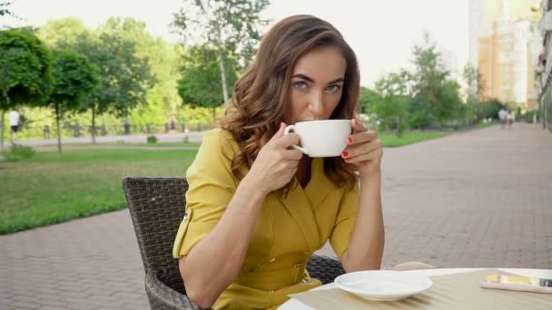 Piękna, elegancka dziewczyna na przerwie na kawę, picie kawy w Caffe, — Wideo stockowe