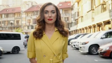 Kamera otoparkta genç çekici bir kız izler.