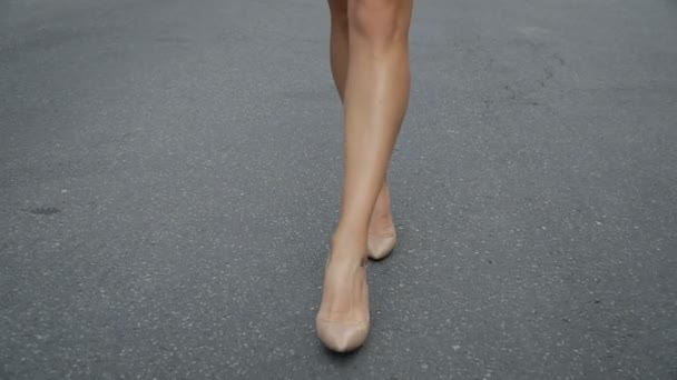 Femmes jambes en chaussures à talons hauts marchant sur la route au ralenti. — Video