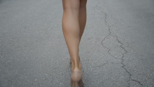 Жінки ноги в туфлях на високих підборах, що ходять по дорозі повільний рух . — стокове відео