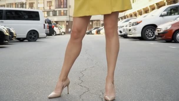 Mädchen im schicken gelben Kleid posiert auf dem Parkplatz. Kameraverkabelung von unten nach oben — Stockvideo