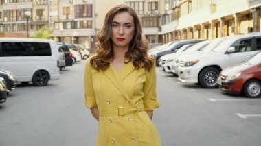 Park alanında poz sarı bir elbise kız. Yukarıdan aşağıya kamera kablolama