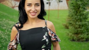 Mutlu gülümseyen esmer yeşil çim üzerinde bir yaz parkında kameradan uzakta çalışır