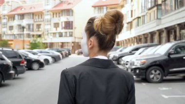 Siyah elbise ceket bir pandomim kız kamera için pozlar.