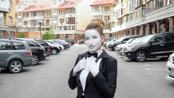 A mime girl in a black dress coat poses for the camera. — Stock Video