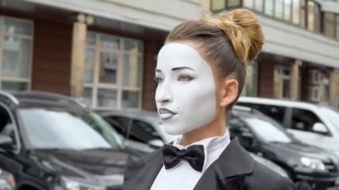 Otoparkta pandomimci kız. Geçiş izni. Kamera, sanatsal bir kızı pandomimci görüntüsünde görüntülüyor..