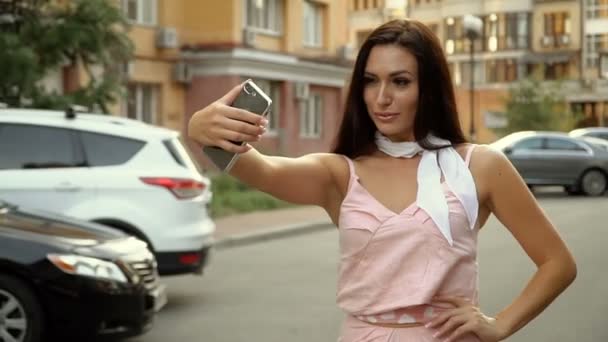 Estilo de vida selfie. Retrato de una joven mujer positiva divirtiéndose y tomando una selfie en el centro de la ciudad. — Vídeos de Stock