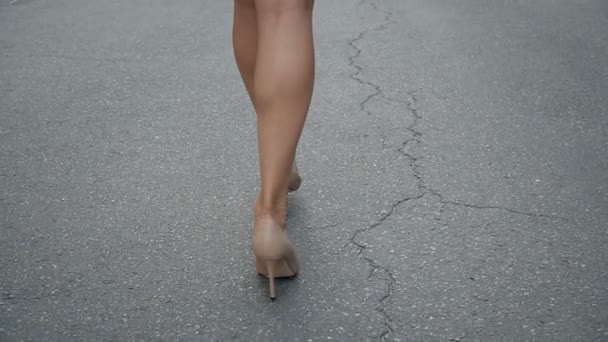 Pernas das mulheres em sapatos de salto alto andando na estrada câmera lenta. — Vídeo de Stock