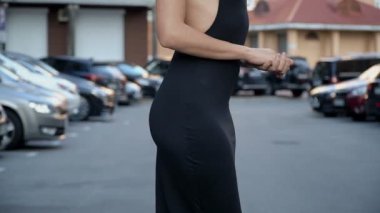 Otoparkta poz şık bir siyah elbise ince kız. Kamera kablolama aşağıdan yukarıya