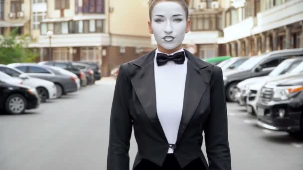 Une fille mime dans une robe noire pose manteau pour la caméra . — Video