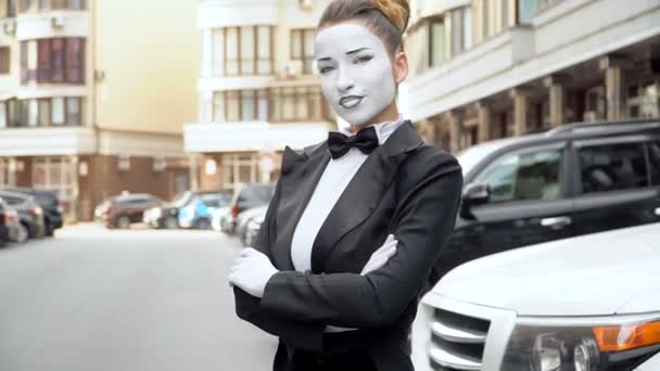 A mime girl in a black dress coat poses for the camera. — Stock Video