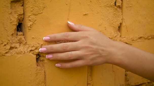 Kvinna hand försiktigt stroke yta, glida på stenig vägg av gamla byggnaden . — Stockvideo