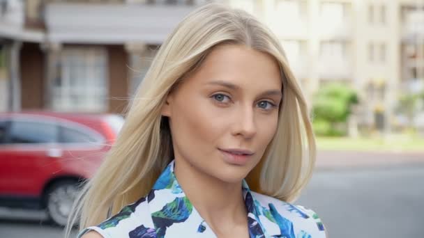 Portret van een blondine op een achtergrond van parkeren — Stockvideo