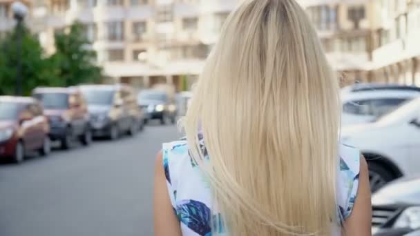 Blond in een zomerpak poserend op de parkeerplaats. Camera bedrading. Vrouwenwandeling — Stockvideo