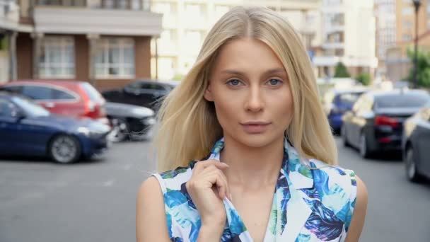 Портрет блондинки на фоне парковки — стоковое видео