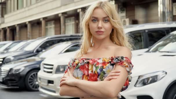 Portrait d'une blonde aux lèvres pleines et aux yeux bleus sur fond de parking — Video