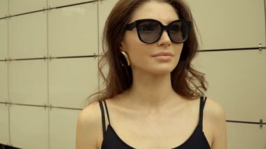 Şehirde yuvarlak gözlüklü, güzel, modern bir kızın portresi. Mevsimlik stil, yaz güzelliği, moda.