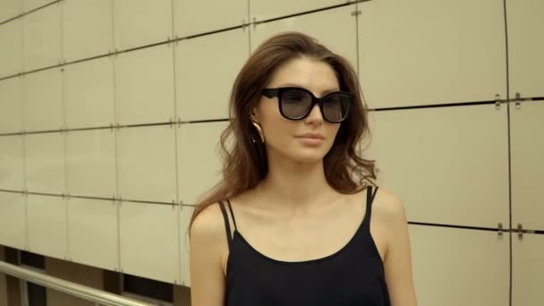 Ritratto di una bella ragazza moderna con occhiali rotondi in città. Stile stagionale, bellezza estiva, moda. — Video Stock