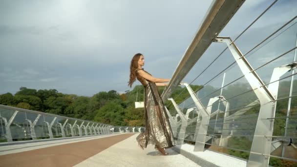 Κορίτσι με ένα κομψό φόρεμα στη γέφυρα της πόλης — Αρχείο Βίντεο