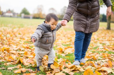 Bebeğin ilk adımları annesi ile parkta yürüyüş