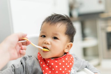 Asya bebek çocuk sandalyesi üzerinde karışım yemek yeme