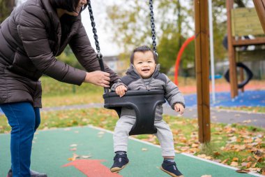 Bebek ve anne paly parkta salıncak