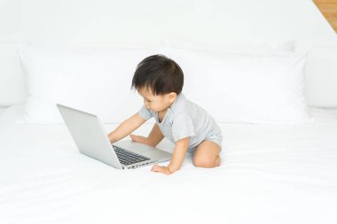 Dizüstü bilgisayar kullanan Asya bebek