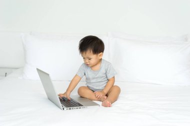 Dizüstü bilgisayar kullanan Asya bebek