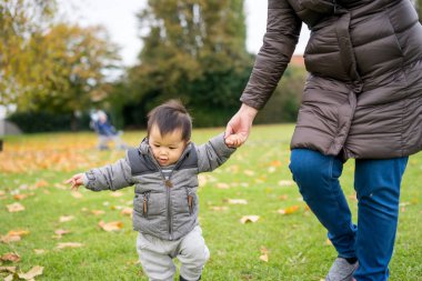 Bebeğin ilk adımları annesi ile parkta yürüyüş
