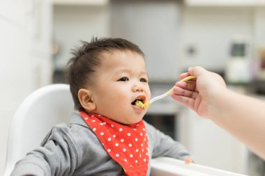 Asya bebek çocuk sandalyesi üzerinde karışım yemek yeme