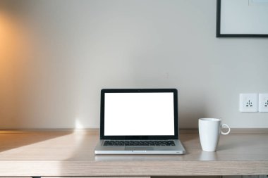 Laptop lambalı bir masanın üstünde.
