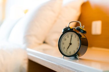 Beyaz yatak odasındaki metal alarm saati