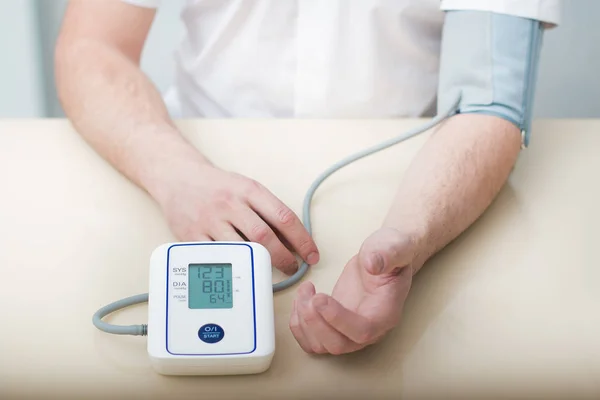 Meting van de bloeddruk door een elektronische tonometer. — Stockfoto