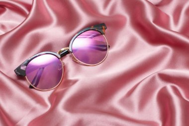 Güzel pembe arka plan üzerinde yuvarlak degrade güneş gözlüğü.