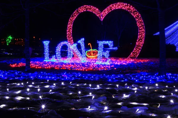 inscription love and heart made of LEDs, in a city park, shot at night