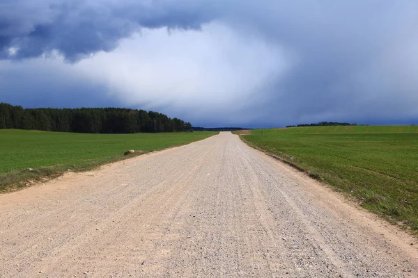 tarlanın ortasında çakıl yol, bir fırtına önce