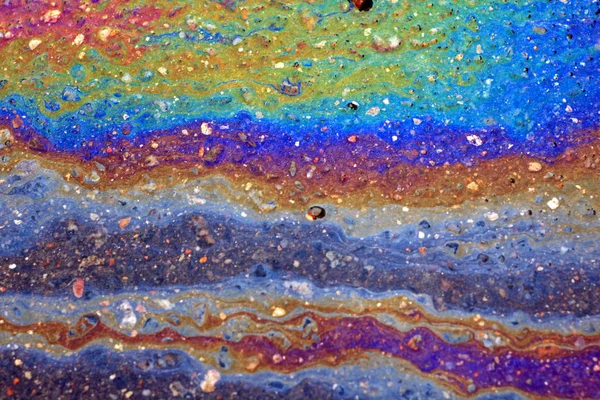 stock image gasoline spreads over the wet asphalt in the form of a multi-colored large spot