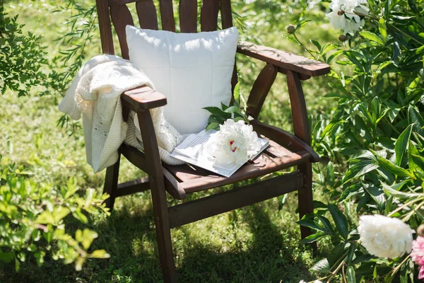 wooden chair in the garden and book