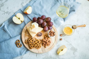 Peynir tabağı ile üzüm, bal, kraker ve fındık ahşap bir tabakta servis