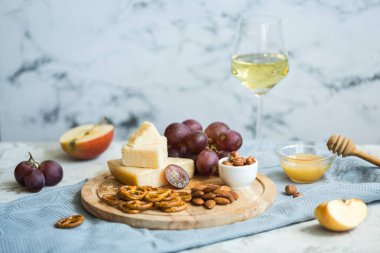 Peynir tabağı ile üzüm, bal, kraker ve fındık ahşap bir tabakta servis