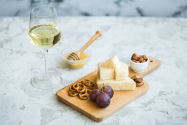Peynir tabağı ile üzüm, bal, kraker ve fındık ahşap bir tabakta servis