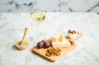 Peynir tabağı ile üzüm, bal, kraker ve fındık ahşap bir tabakta servis