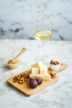 Peynir tabağı ile üzüm, bal, kraker ve fındık ahşap bir tabakta servis